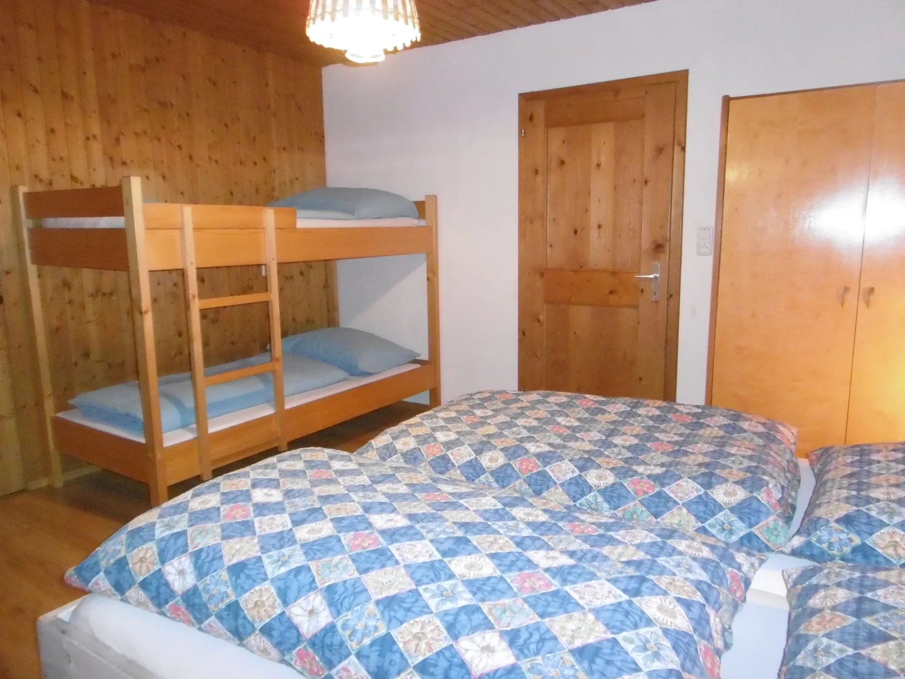 Schlafzimmer mit Doppelbett und Stockbett im Obergeschoss