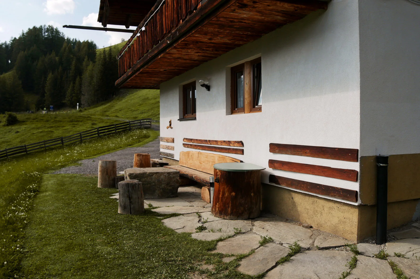 Sonnenbank mit Steintisch vor dem Ferienhaus Anderles-Alm